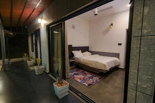 a bedroom with a bed and a large window at The Cozy Winterfell in Munnar