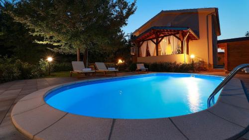 Una piscina en un patio trasero por la noche. en Apartment Sonja 1, en Šilo