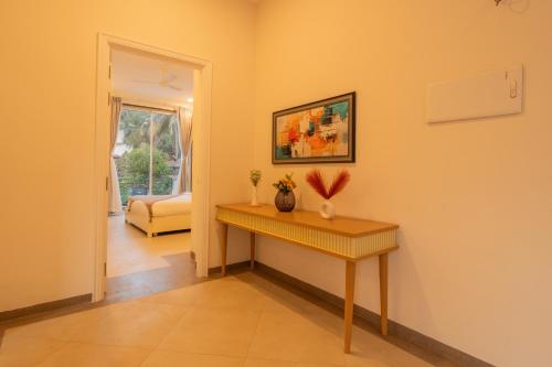 a living room with a table and a couch at ELIVAAS Laguna Encanto 4 BHK Villa with Pvt Pool & Terrace in Anjuna