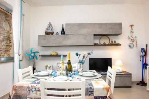 a dining room with a table with white chairs at Casa Vacanze - Li Nassi in Stintino