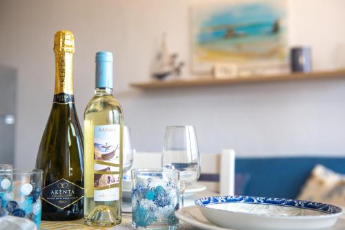 a bottle of wine and a glass on a table at Casa Vacanze - Li Nassi in Stintino