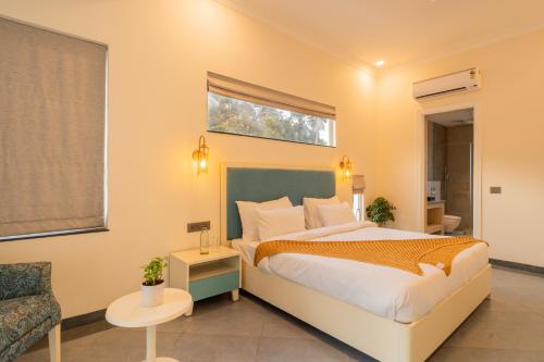 a hotel room with a bed and a chair at ELIVAAS Laguna Encanto 4 BHK Villa with Pvt Pool & Terrace in Anjuna