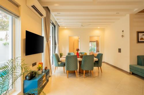 a dining room with a table and chairs at ELIVAAS Laguna Encanto 4 BHK Villa with Pvt Pool & Terrace in Anjuna