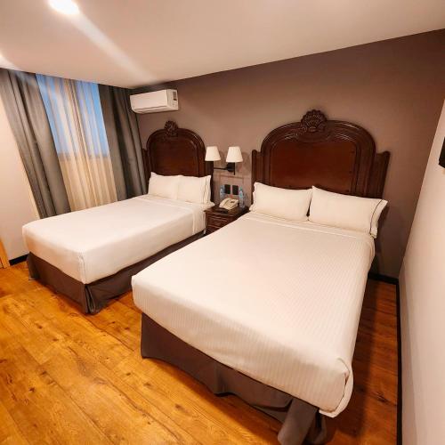 a hotel room with two beds and a night stand at Canada Central & Rooftop in Mexico City
