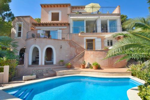 a villa with a swimming pool in front of a house at Villa with incredible sea views and pool Up To 7 in Andratx