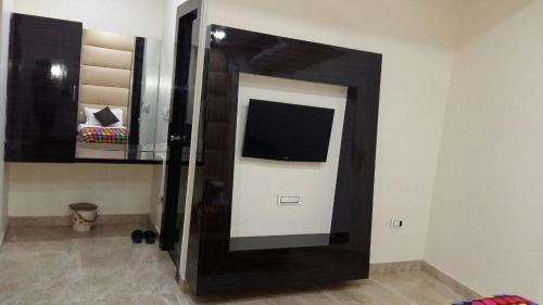 a room with a flat screen tv on a wall at Hotel Samrat in Gurgaon