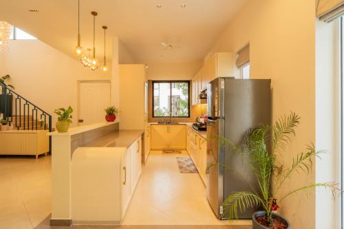 a kitchen with a stainless steel refrigerator at ELIVAAS Laguna Encanto 4 BHK Villa with Pvt Pool & Terrace in Anjuna