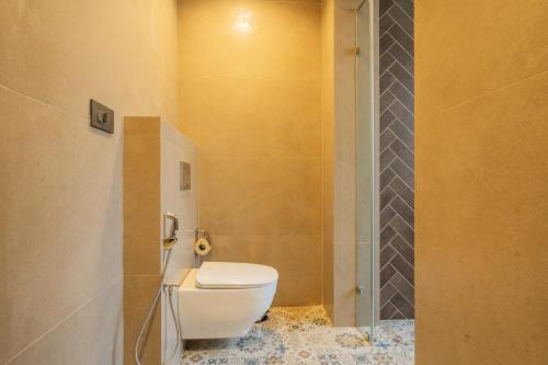 a bathroom with a toilet and a shower at ELIVAAS Laguna Encanto 4 BHK Villa with Pvt Pool & Terrace in Anjuna