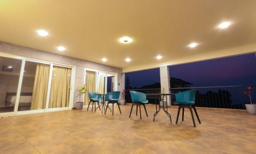 a room with a table and chairs on a balcony at The Cozy Winterfell in Munnar