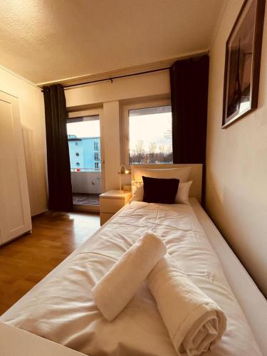 a large white bed in a room with a window at B2 XL Top I 130m2 I 10 Einzelbetten I voll ausgestattet I Balkon I Wasch I XXL P in Mettingen