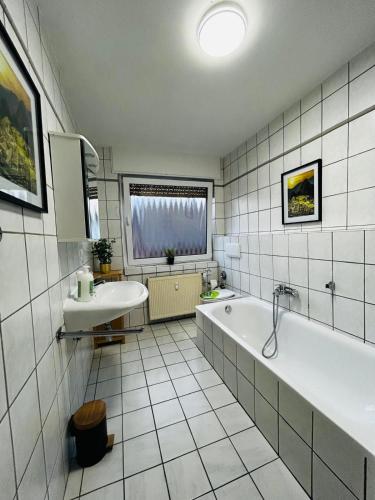 a bathroom with a tub and a sink at B2 XL Top I 130m2 I 10 Einzelbetten I voll ausgestattet I Balkon I Wasch I XXL P in Mettingen