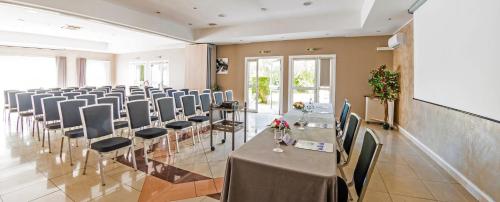 a conference room with a long table and chairs at Hôtel Ariane in Istres