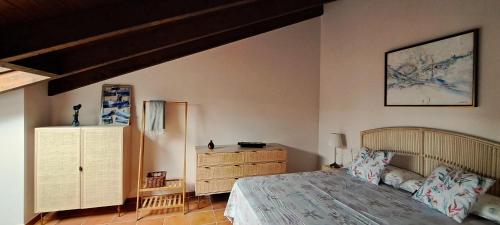 a bedroom with a bed and a dresser in it at Precioso Ático con Vistas en El Capricho de Colombres, Asturias in Colombres
