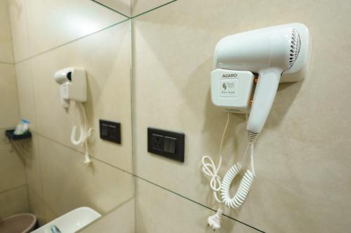 a hairdryer on a wall in a bathroom at The Cozy Winterfell in Munnar