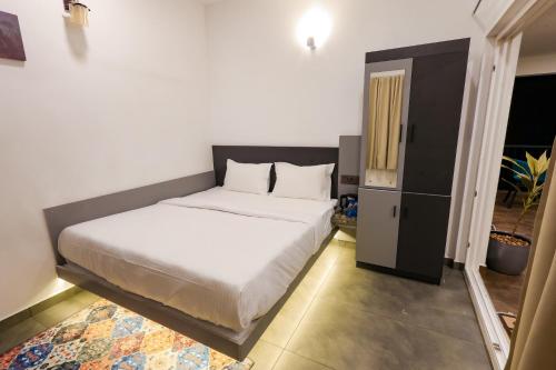 a bedroom with a bed and a small cabinet at The Cozy Winterfell in Munnar
