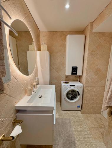 une salle de bain avec une machine à laver et un lavabo dans l'établissement Studio climatisé, terrasse, parking privé, 50m de la plage, à Saint-Tropez