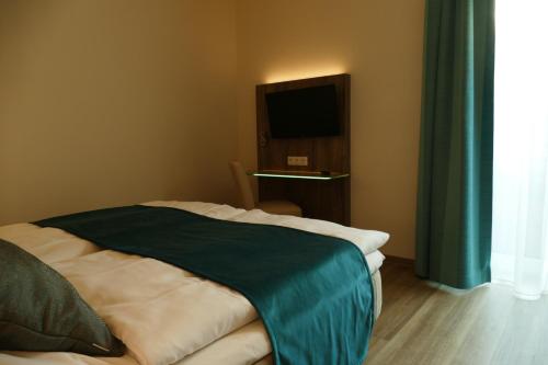 a bedroom with a bed with a tv on the wall at Meyn's Apartments in Soltau