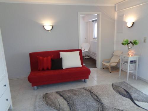a living room with a red couch with pillows at Ferienwohnung "Am Recknitzhang" in Daskow