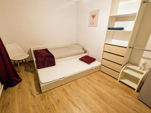 une petite chambre avec un lit et un bureau dans l'établissement Appart COSY 2 ch avec Terrasse privé & BBQ, à Charmes