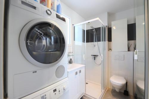 - un lave-linge dans une salle de bains blanche pourvue de toilettes dans l'établissement Carro, à Martigues