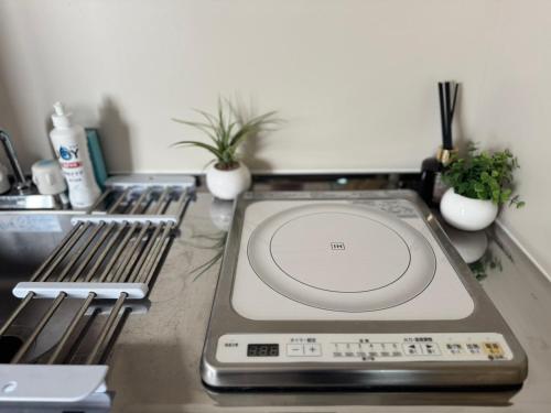 a kitchen counter top with a sink and a stove at Palasto Hostel in Tokyo