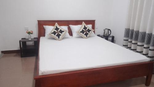 a bedroom with a bed with white sheets and pillows at King Elephant, Homestay Pinnawala in Rambukkana