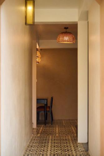 a hallway with a table and a chair and a light at Mật Retreat in Ba Vì