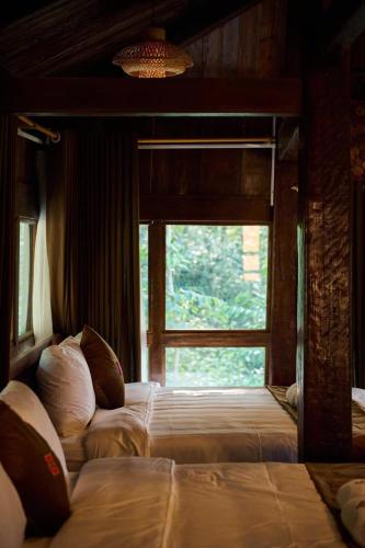 a bedroom with two beds and a window at Mật Retreat in Ba Vì