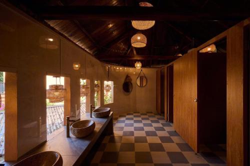 a hallway with a checkered floor and some chairs at Mật Retreat in Ba Vì