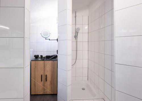 a white bathroom with a shower and a sink at Altbauoase Fulda - ruhig, zentral, Terrasse, Bahnhof 400m - in Fulda