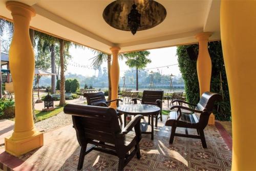 a patio with chairs and a table on a porch at SHEIK ISTANA HOTEL CHIANGMAl in Chiang Mai