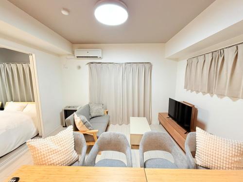 a living room with a bed and a tv at Sun Court Nango-dori サンコート南郷通 801 in Sapporo