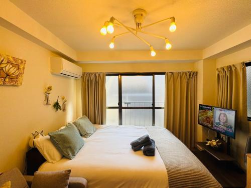 a bedroom with a large bed with a window at Palasto Hostel-SJ0002 in Tokyo
