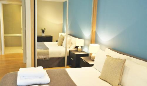 a hotel room with a bed and a mirror at Spacious & Elegant Apartments in Southbank near London Eye in London