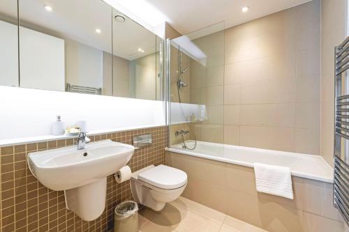 a bathroom with a sink and a toilet and a tub at Spacious & Elegant Apartments in Southbank near London Eye in London