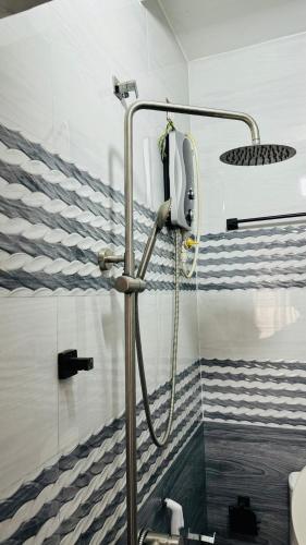 a shower in a bathroom with blue and white stripes at Transit stay seeduwa in Mukalangamuwa