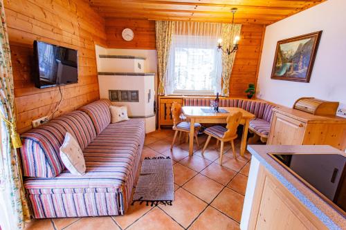 salon z kanapą i stołem w obiekcie Bergidyll 6 by Alpenidyll Apartments w mieście Ramsau am Dachstein