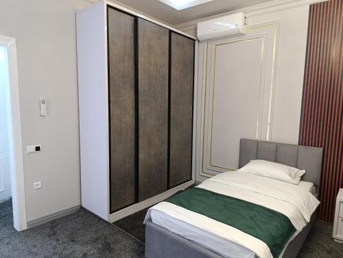 a bedroom with a bed with a wooden headboard at GRAND SARBON HOTEL in Qarshi
