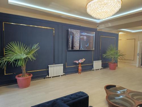 a living room with blue walls and potted plants at GRAND SARBON HOTEL in Qarshi