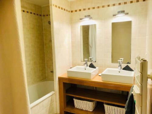 une salle de bain avec deux lavabos et une baignoire dans l'établissement Grand Bleu T3 sur quai plaisancier, Garage, Clim, à Sète