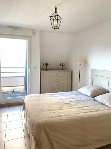 une chambre avec un grand lit et une fenêtre dans l'établissement Grand Bleu T3 sur quai plaisancier, Garage, Clim, à Sète