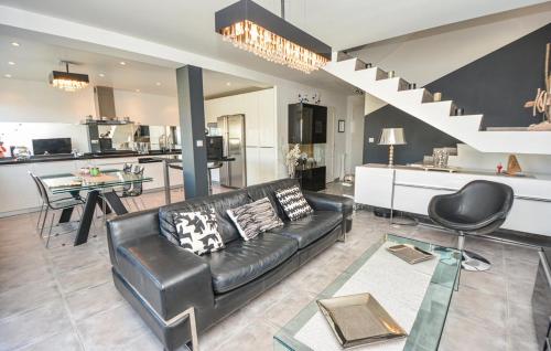 Il comprend un salon avec un canapé en cuir noir et une cuisine. dans l'établissement Carro, à Martigues