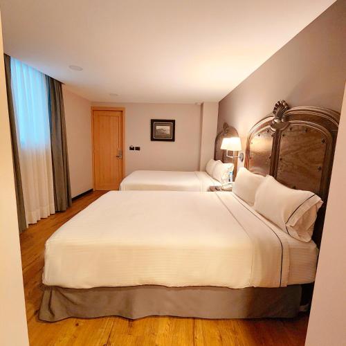 a hotel room with two beds and a window at Canada Central & Rooftop in Mexico City