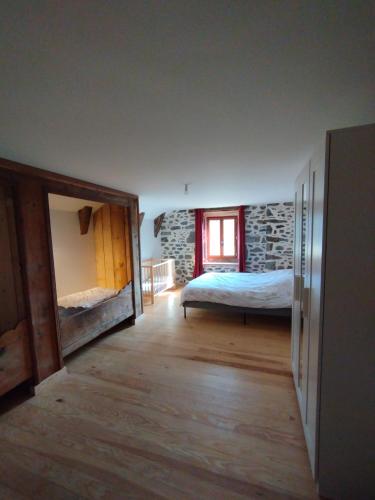 une chambre avec un lit et une fenêtre dans l'établissement Domaine des Hiboux, à Chastreix