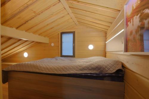 a bedroom with a bed in a wooden room at Tunturipöllö 2 in Ruka