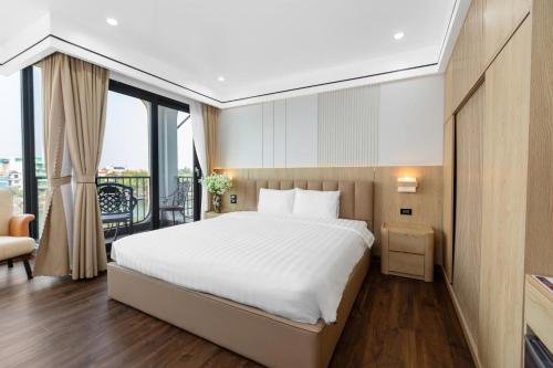 a bedroom with a large white bed and a balcony at Khách sạn Phố cổ Hotel Ninh Bình in Ninh Binh