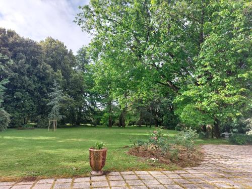 un jardin avec une pelouse et des arbres dans l'établissement Le pré de Bonhomme, à Le Mazeau