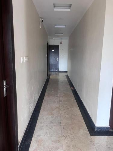 an empty hallway with a door and a tile floor at HOTEL SHIVGANGA COMFORT ZONE, Raipur in Raipur