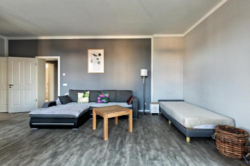 a living room with a couch and a bed and a table at FeWo Droyßig Villa Edelgard in Droyßig