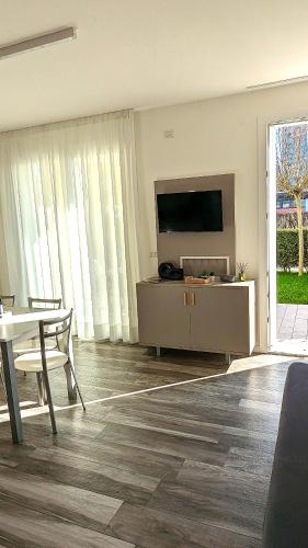 a living room with a flat screen tv and a table at Mazzini Green Suites Jesolo in Lido di Jesolo